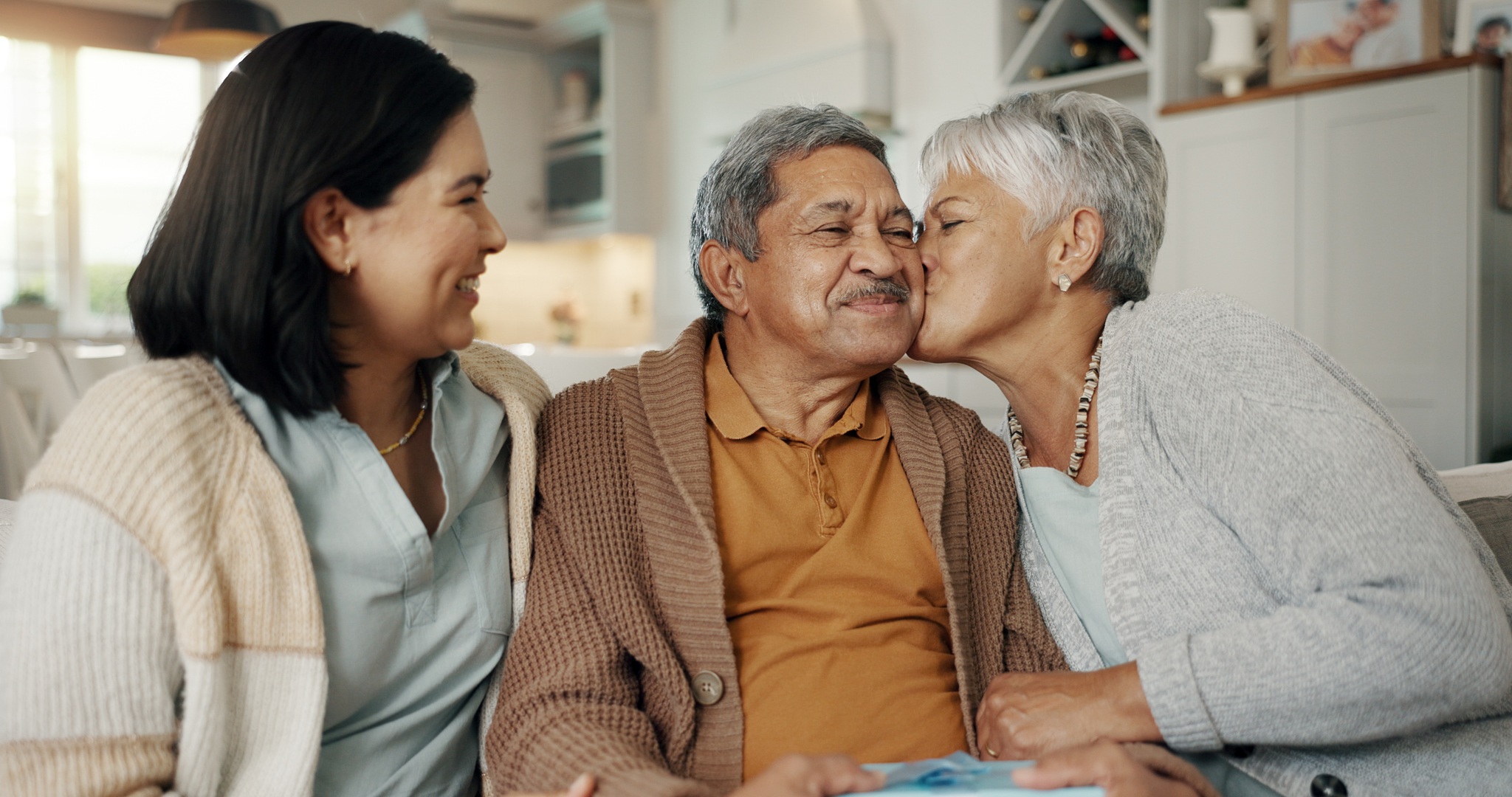 Family moment with elderly couple and younger woman in kitchen