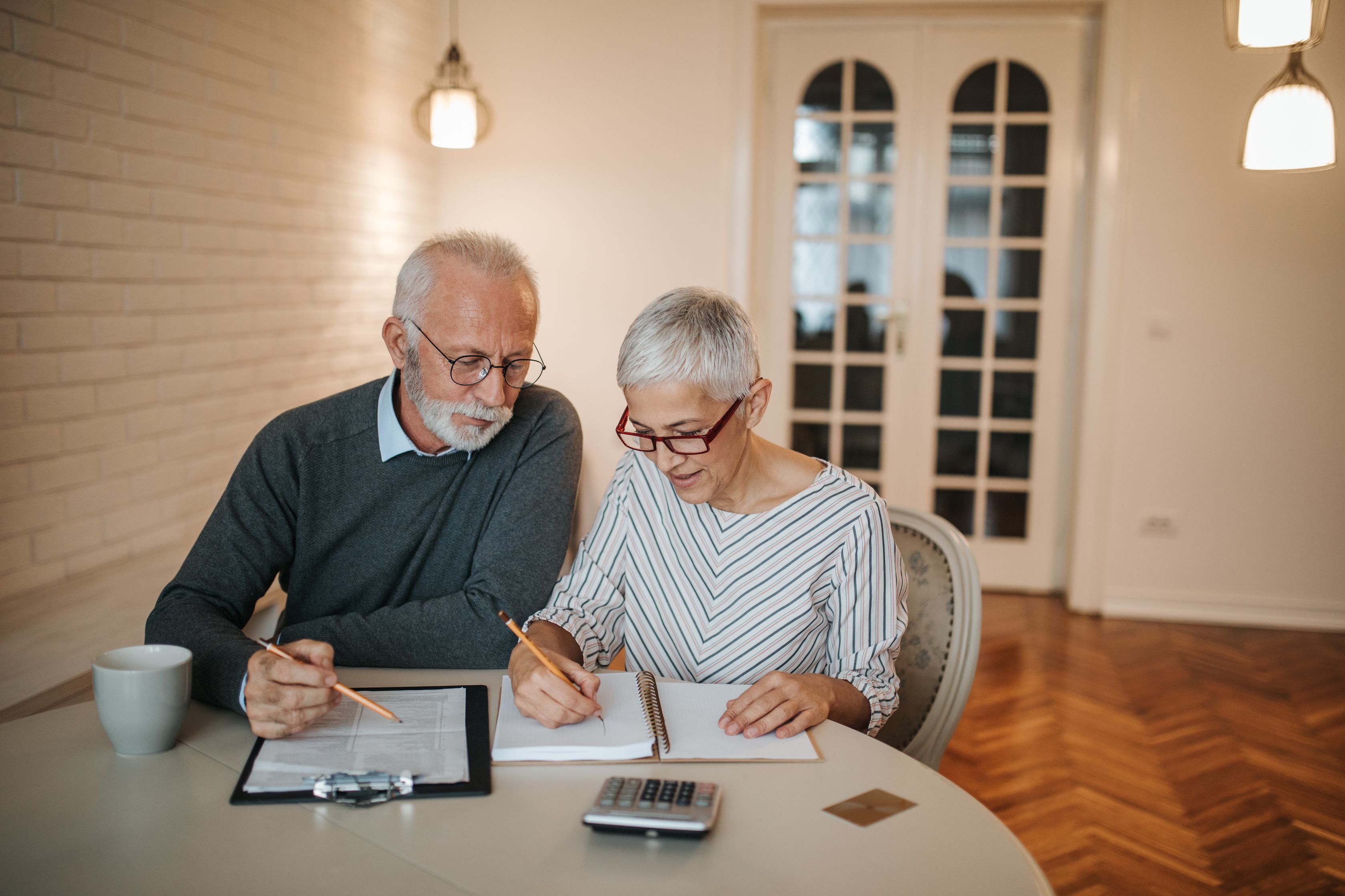 Senior couple reviewing financial documents together at home