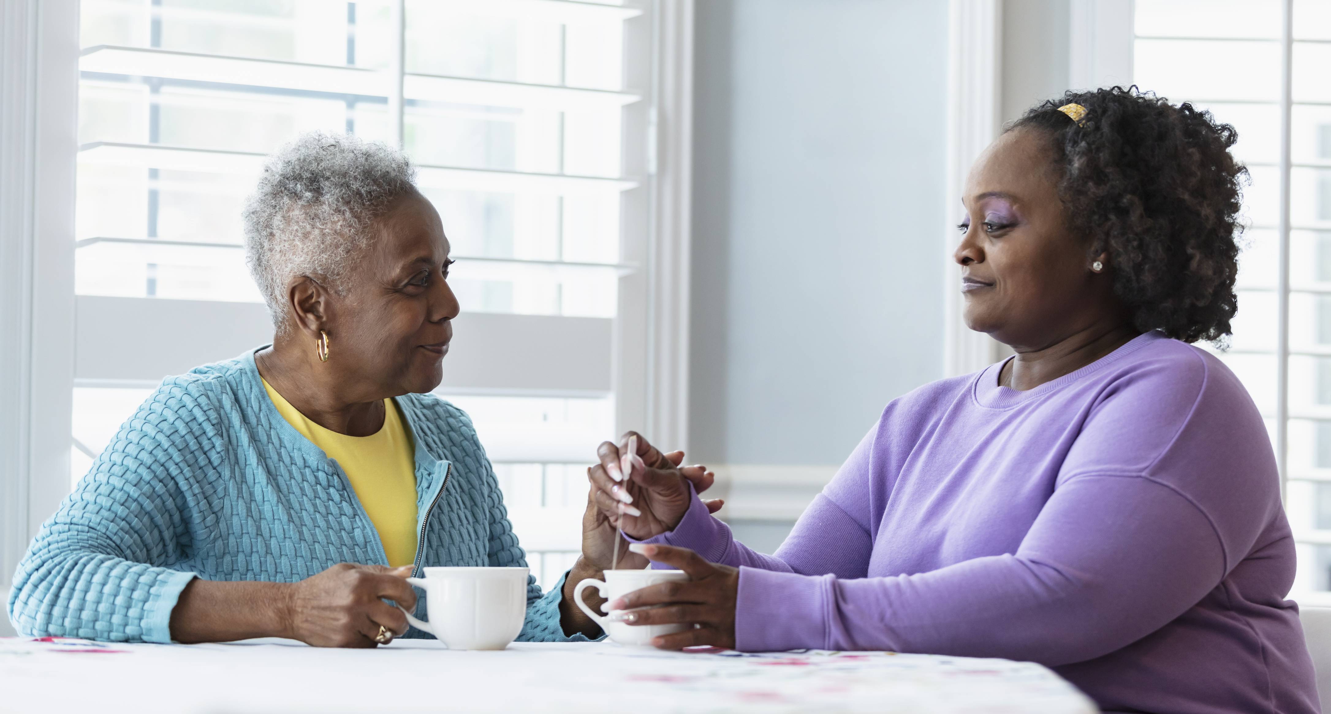 Two women having coffee and conversation at a bright table