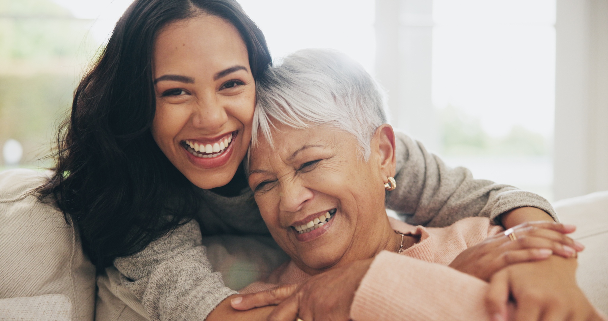 Two women smiling and embracing in warm affectionate hug